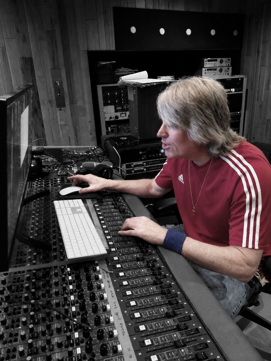 Denny Kubas seated at the mixing console in the studio